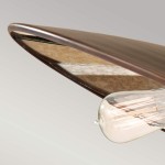 Lampa wisząca Urban Renewal w rustykalnym mosiądzu z trzema oprawami E27. Ujęcie z boku, ukazujące zaokrągloną, metalową osłonę oraz przezroczystą żarówkę w kształcie kropli, zawieszoną w centralnej części. Tło jasne, minimalistyczne.