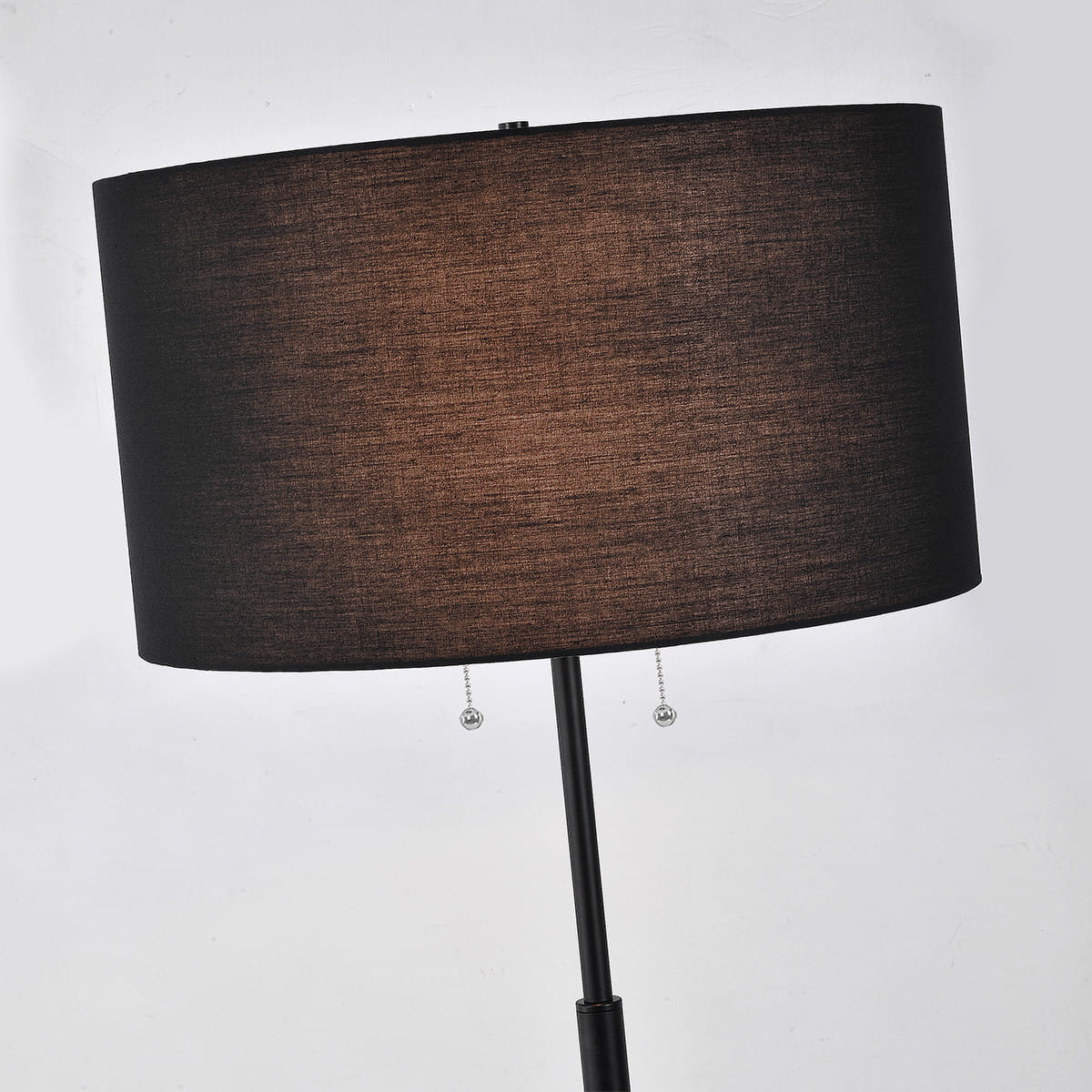 Lampa podłogowa Fogo 2xE27 w kolorze czarnym, z prostym, owalnym abażurem z tkaniny. Ustawiona w pionie, z dwoma szklanymi, wiszącymi przełącznikami. Idealna do nowoczesnych wnętrz, zapewniająca ciepłe oświetlenie.