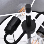 Lampa podłogowa Fogo w kolorze czarnym z dwoma gniazdami E27. Zbliżenie na elementy konstrukcyjne, w tym czarny uchwyt oraz przezroczyste żarówki z widocznymi włóknami. Prosta, nowoczesna forma z metalowym stelażem.