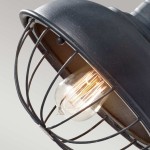 Lampa wisząca Urban Renewal z antycznego, kutego żelaza, z metalową osłoną w formie klatki. Widoczna żarówka E27 o szklanym kloszu, emitująca ciepłe światło. Ujęcie z góry, ukazujące detale konstrukcji oraz fakturę materiału.