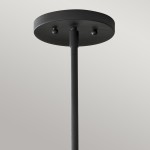 Czarna lampa wisząca Woodstock L z mocowaniem na 6 żarówek E14. Widoczny okrągły sufitowy uchwyt z metalowym wykończeniem, prosty, minimalistyczny design, zwisająca na cienkim, prostokątnym stelażu.