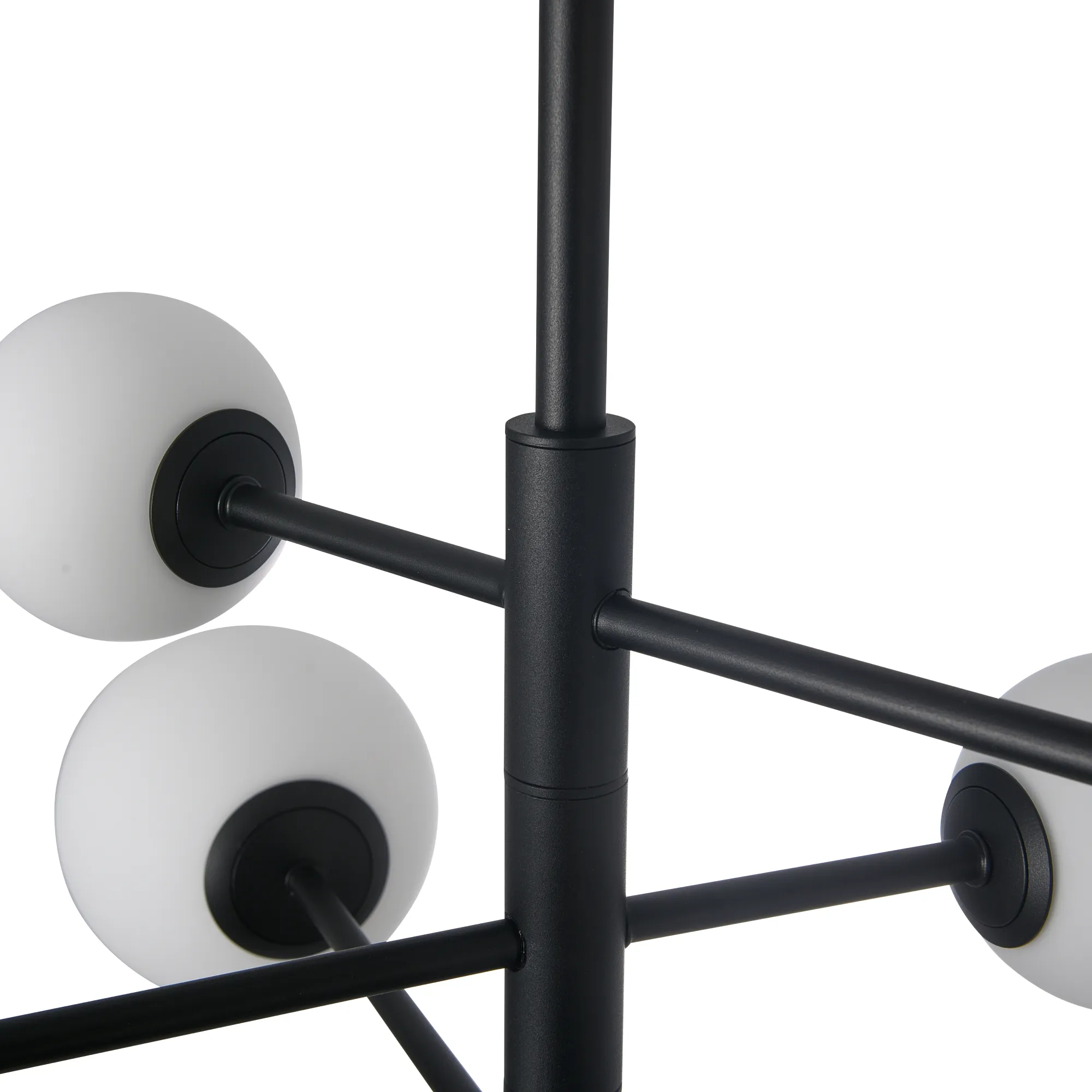 Lampa wisząca Bolti w kolorze czarnym z sześcioma oprawami G9. Konstrukcja z metalowych prętów z matowym wykończeniem, na końcach białe, szklane klosze w kształcie kul. Ujęcie z bliska, pokazujące detale mocowania i kloszy.