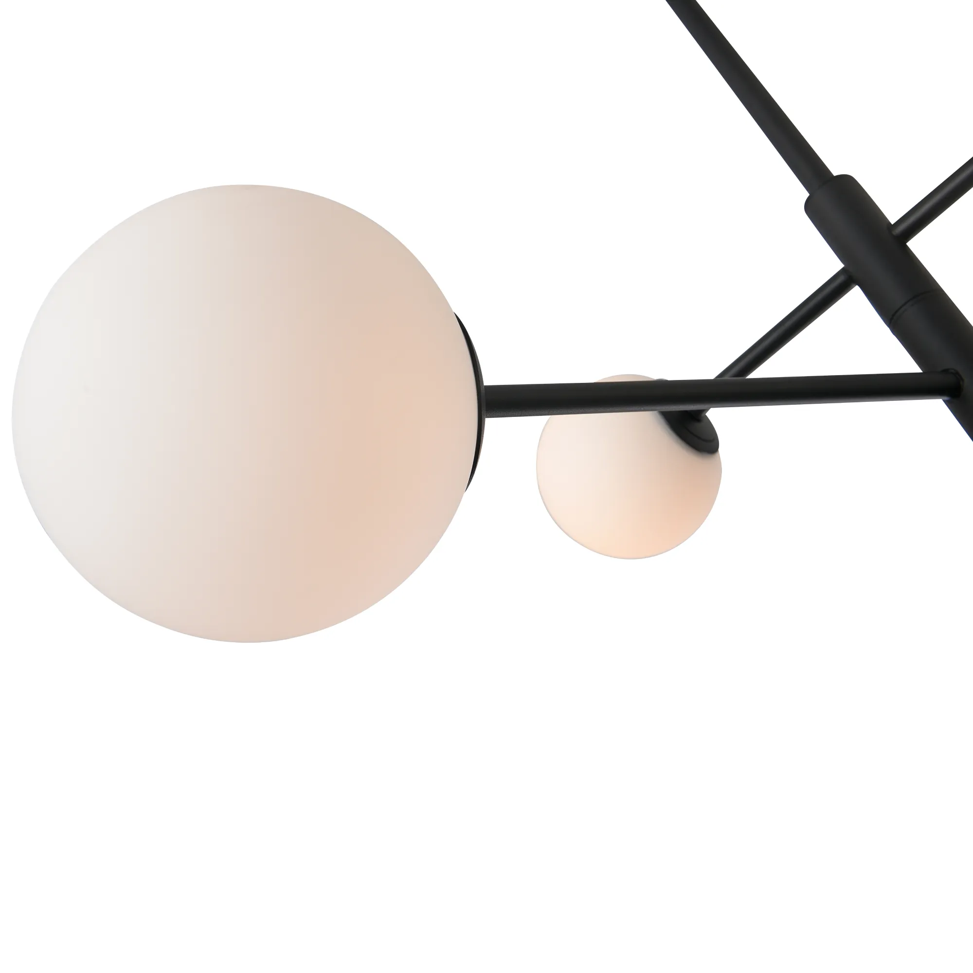 Lampa wisząca Bolti w kolorze czarnym z sześcioma oprawkami G9, z widocznymi białymi, szklanymi kulami, zawieszona na metalowych prętach. Ujęcie z dołu, ukazujące detale konstrukcji oraz różne wielkości kul. Tło białe, minimalistyczne.