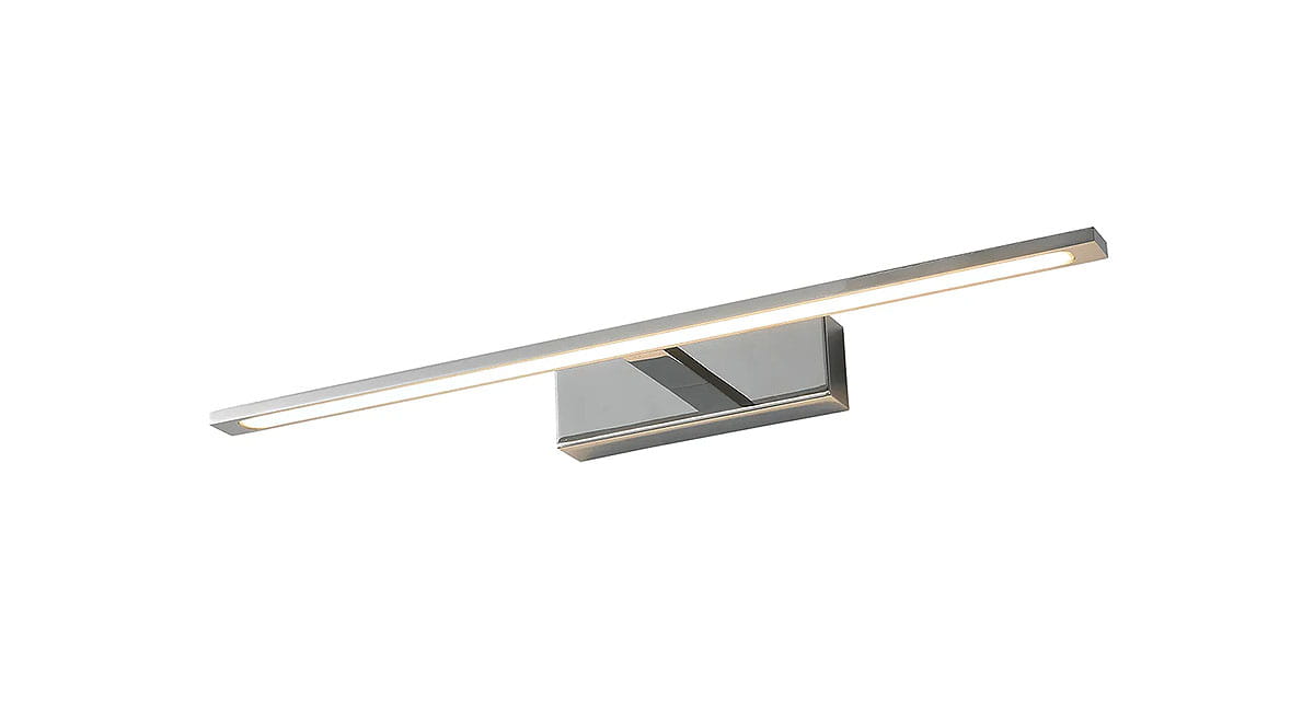 Kinkiet łazienkowy LED Elgidia IP44 w kolorze chromu, o prostokątnej formie, z wbudowanym oświetleniem LED. Produkt zamontowany na ścianie, z widoczną, wąską listwą świetlną, emitującą ciepłe światło.