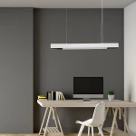 Lampa wisząca Cali 80 w kolorze białym, z jedną diodą LED o mocy 32W, zawieszona nad biurkiem. Oprostokątny kształt z delikatnymi otworami wentylacyjnymi, w nowoczesnym wnętrzu z szarymi ścianami i drewnianym biurkiem.