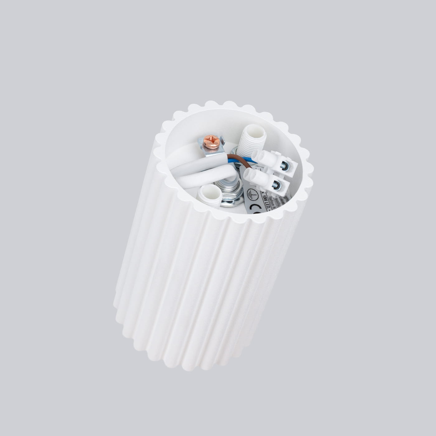 Lampa sufitowa Karbon 10, biała, z oprawą na jedną żarówkę GU10. Widoczny detal wnętrza z przewodami i złączkami, o cylindrycznym kształcie z rowkowaną fakturą. Ujęcie z góry, na jednolitym tle.