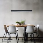 Lampa wisząca Mira 120 w kolorze czarnym, z jednym źródłem światła LED o mocy 45W, zawieszona nad drewnianym stołem z roślinami w doniczkach. Prosty, nowoczesny design, umieszczona w jasnym wnętrzu z białymi krzesłami.