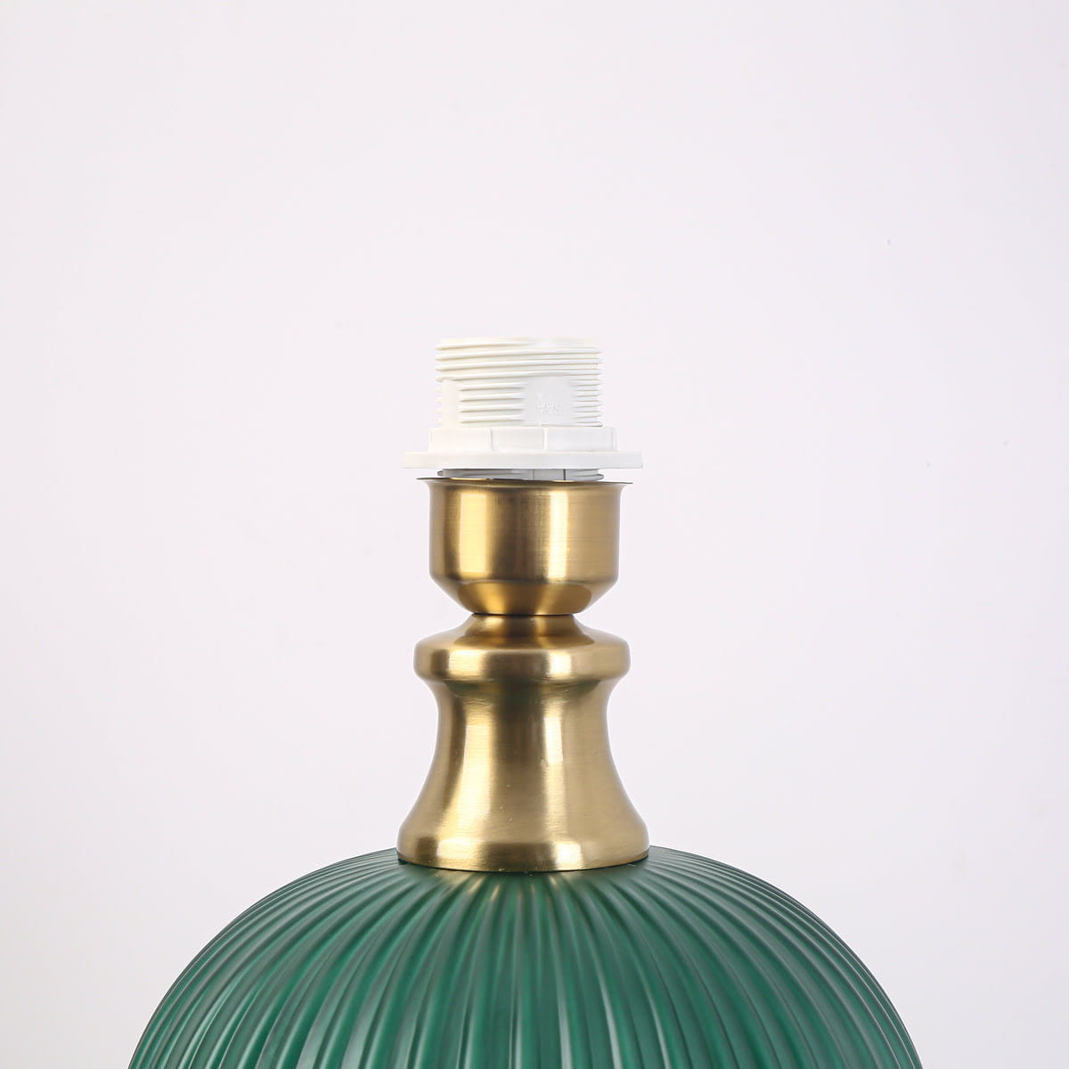 Lampa stołowa Tamiza w butelkowej zieleni, z metalowym, złotym trzonkiem i miejscem na żarówkę E27. Widoczna struktura klosza z pionowymi rowkami. Kąt ujęcia zbliżony na górną część lampy.