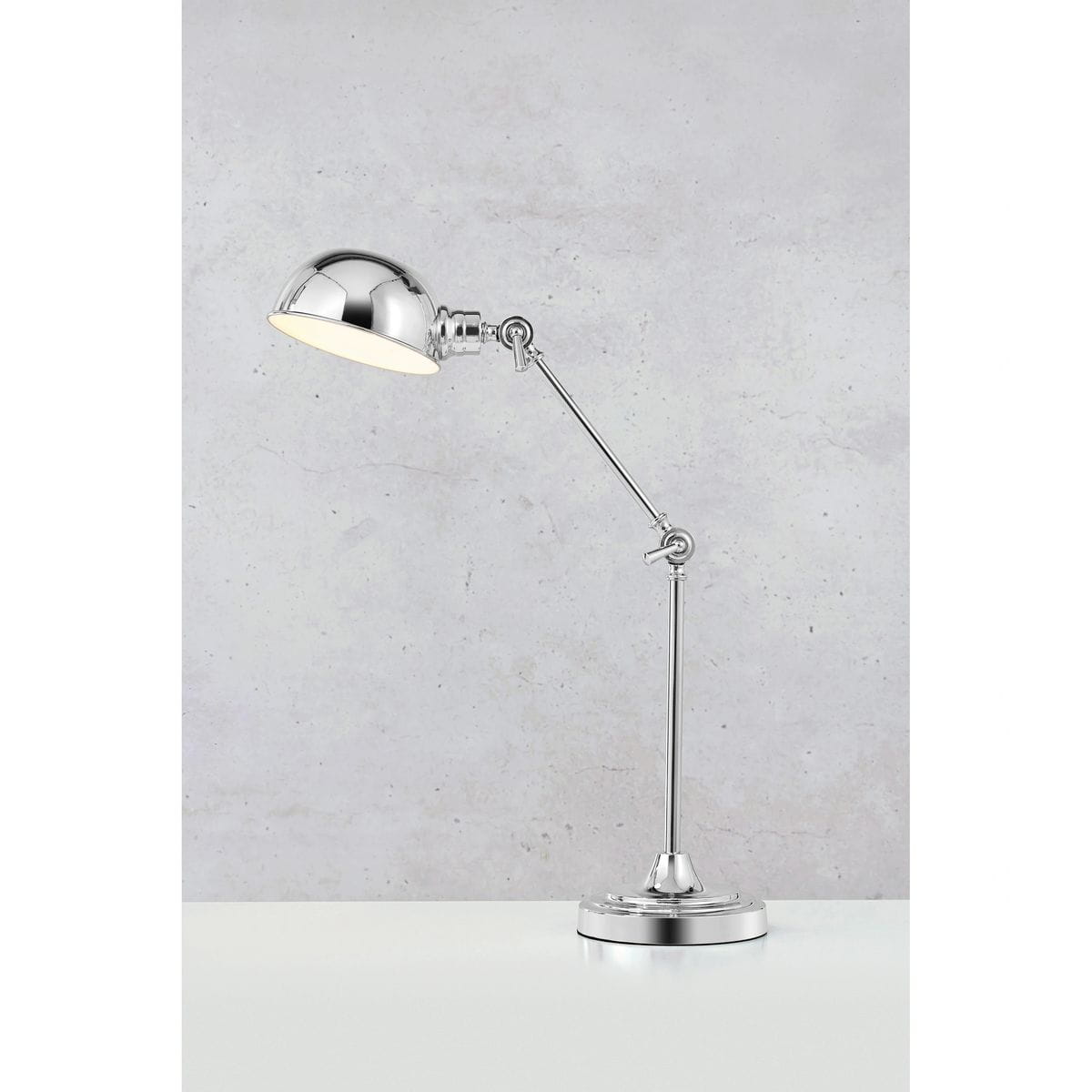 Lampa biurkowa Portland w kolorze chromu z regulowanym ramieniem i okrągłą podstawą. Klosz o półkulistym kształcie skierowany w dół, z jedną oprawą E27. Ujęcie z boku na jasnym tle, ukazujące detale konstrukcji i wykończenia.