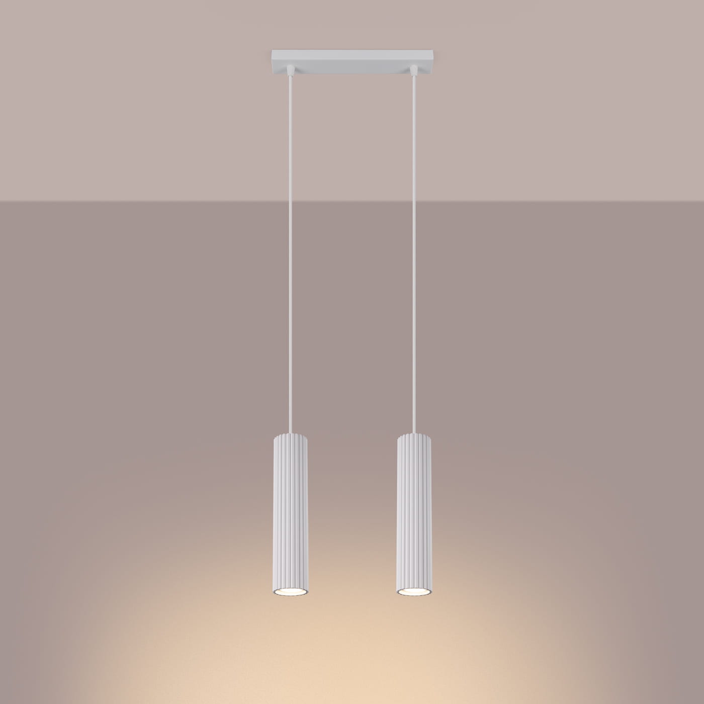 Lampa wisząca Karbon 2 z dwoma cylindrycznymi kloszami w kolorze białym, zawieszona na cienkich linkach. Klosze mają teksturowaną, żeberkowaną powierzchnię. Lampa montowana do sufitu, idealna do nowoczesnych wnętrz.