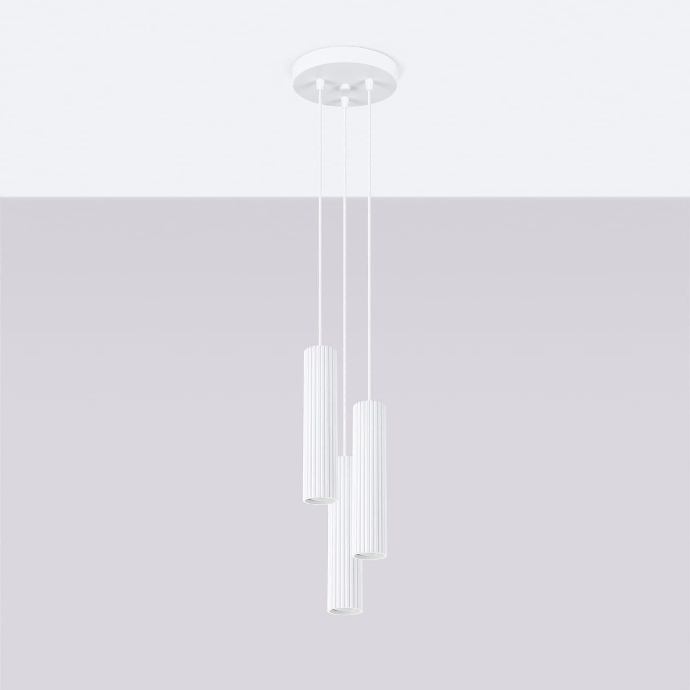 Lampa wisząca Karbon 3P w kolorze białym z trzema cylindrycznymi kloszami z rowkowanej powierzchni, zawieszona na cienkich linkach, zamocowana do okrągłej podstawy sufitowej. Idealna do nowoczesnych wnętrz.