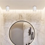 Biała lampa sufitowa tuba 1-punktowa IP65, zamontowana na suficie w nowoczesnym wnętrzu. W tle widoczna marmurowa ściana oraz okrągłe lustro. Lampa ma prosty, cylindryczny kształt i emituję światło skierowane w dół.