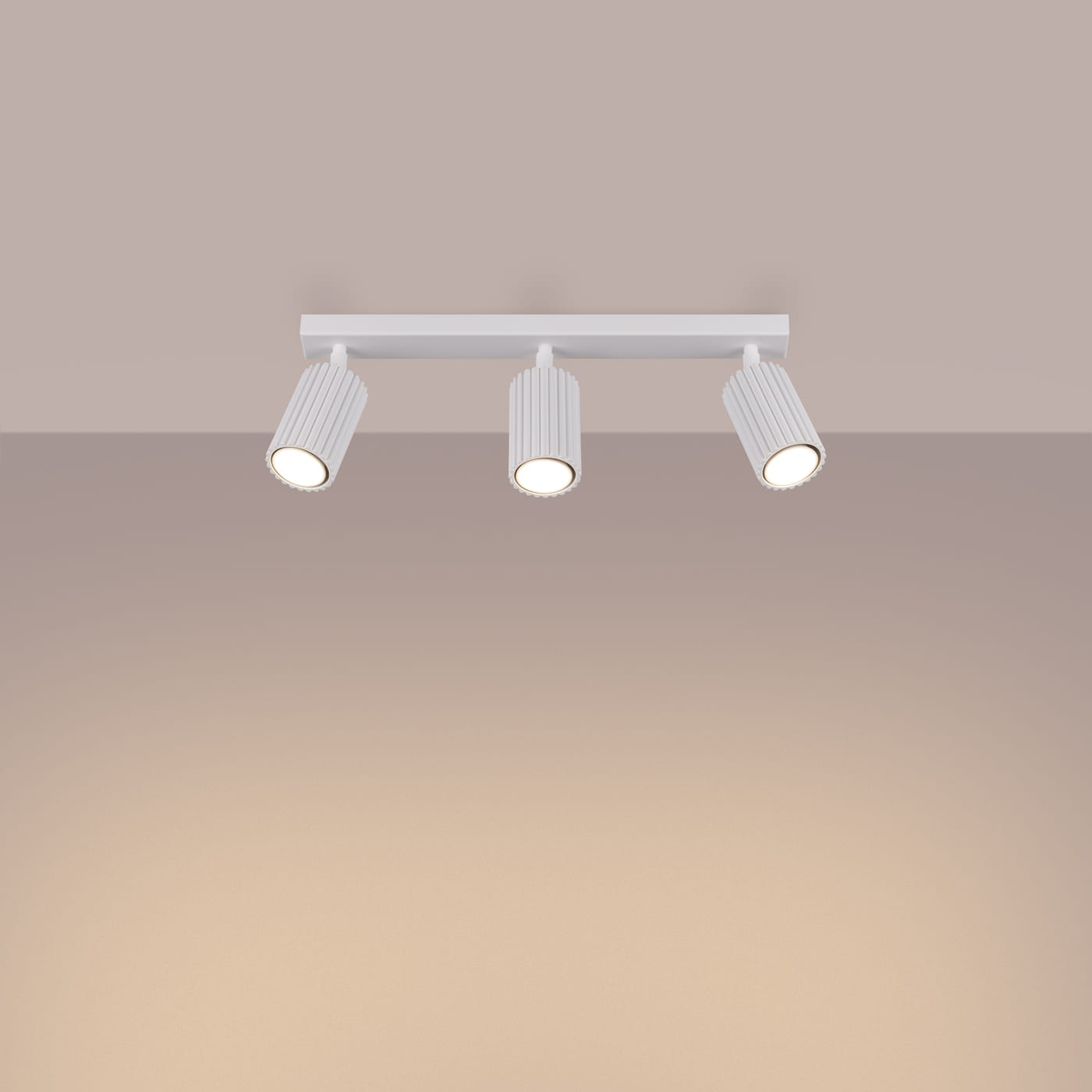 Lampa sufitowa Karbon (spot) z trzema źródłami światła GU10, w białym kolorze. Ujęcie frontalne, przedstawiające lampę z poziomu sufitu, z widocznymi cylindrycznymi kloszami z żłobieniami. Montaż na płaskiej powierzchni.