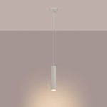 Beżowa lampa wisząca Karbon 1 z jednym gniazdem GU10, o cylindrycznym kształcie z pionowymi żłobieniami. Zawieszona na cienkim, białym przewodzie, emitująca ciepłe światło w jednolitym, stonowanym tle.