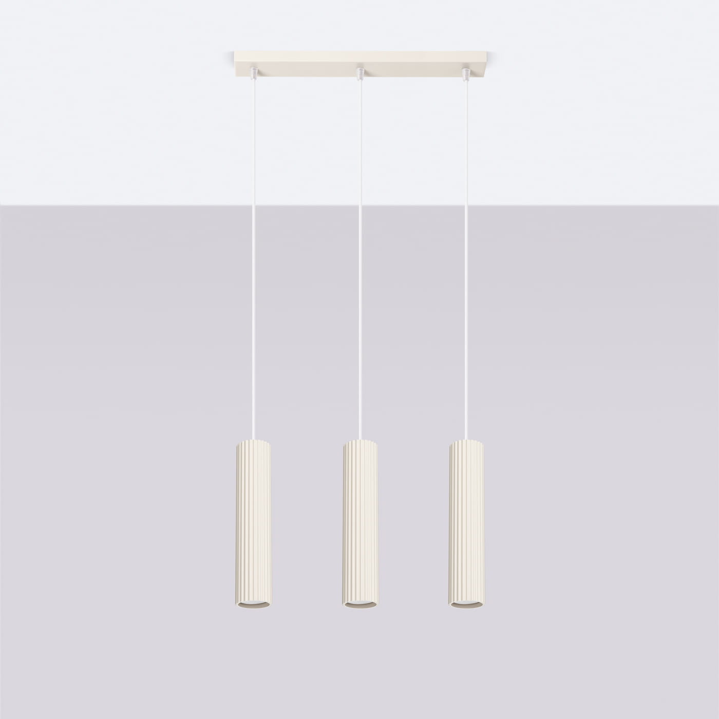 Lampa wisząca Karbon 3 z trzema cylindrycznymi kloszami w beżowym kolorze, zawieszona na białych linkach. Klosze mają teksturowaną powierzchnię z pionowymi żłobieniami. Montaż sufitowy na prostokątnej podstawie w kolorze białym.