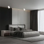 Lampa sufitowa Kendal (spot) 1xGX53 w kolorze białym, zamontowana na suficie w sypialni. Ujęcie z boku, ukazujące ruchomą konstrukcję i subtelne oświetlenie, w nowoczesnym wnętrzu z łóżkiem i zasłonami.