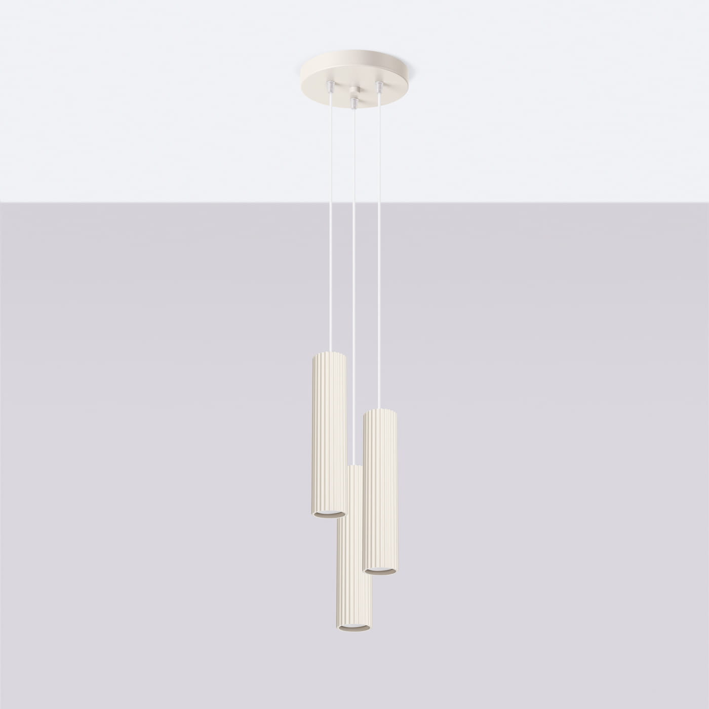 Lampa wisząca Karbon 3P w kolorze beżowym z trzema cylindrycznymi kloszami o żebrowanej fakturze, zawieszona na cienkich linkach. Klosze mają otwarte końce, a lampa jest zamontowana na okrągłej podstawie sufitowej.