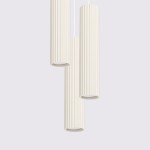 Lampa wisząca Karbon 3P w kolorze beżowym, składająca się z trzech cylindrycznych kloszy z rowkowaną fakturą, zawieszona na białym przewodzie. Klosze mają otwarte końce, co umożliwia zastosowanie żarówek GU10. Tło proste, jasne.