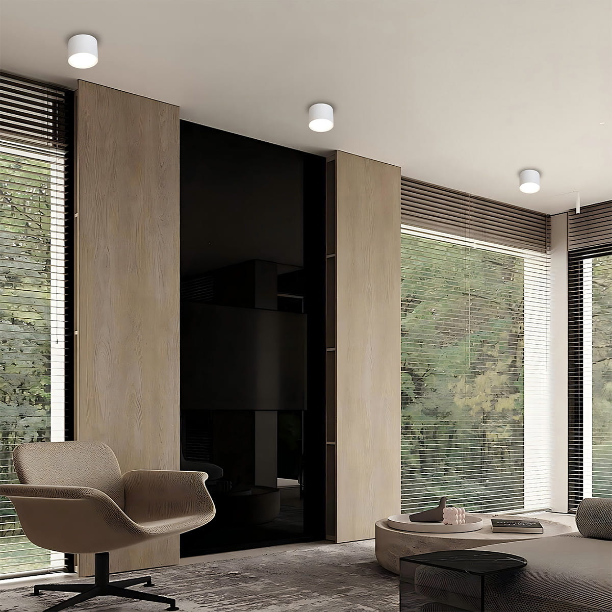 Biała lampa sufitowa Kendal z oprawą GX53, zamontowana na suficie w nowoczesnym wnętrzu. Kształt cylindryczny, minimalistyczny design. Widoczna w kontekście pokoju z drewnianymi panelami i dużymi oknami z roletami.