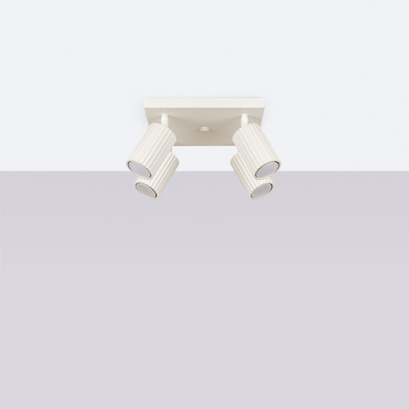 Beżowa lampa sufitowa typu spot z czterema oprawami GU10, umieszczona na kwadratowej podstawie. Reflektory o cylindrycznym kształcie z teksturowaną powierzchnią, skierowane w różne strony, zapewniające elastyczność w oświetleniu.