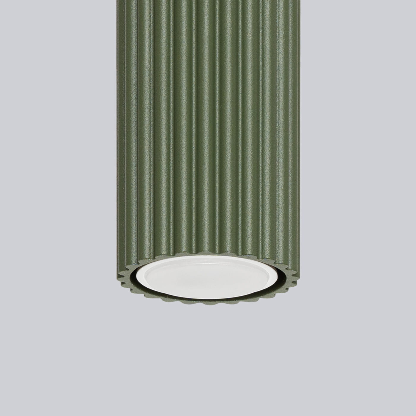 Lampa sufitowa Karbon 10 w kolorze oliwkowym z teksturowanym, żłobkowanym kloszem. Ujęcie z dołu, pokazujące gniazdo na żarówkę GU10. Tło w jednolitym, jasnym kolorze.