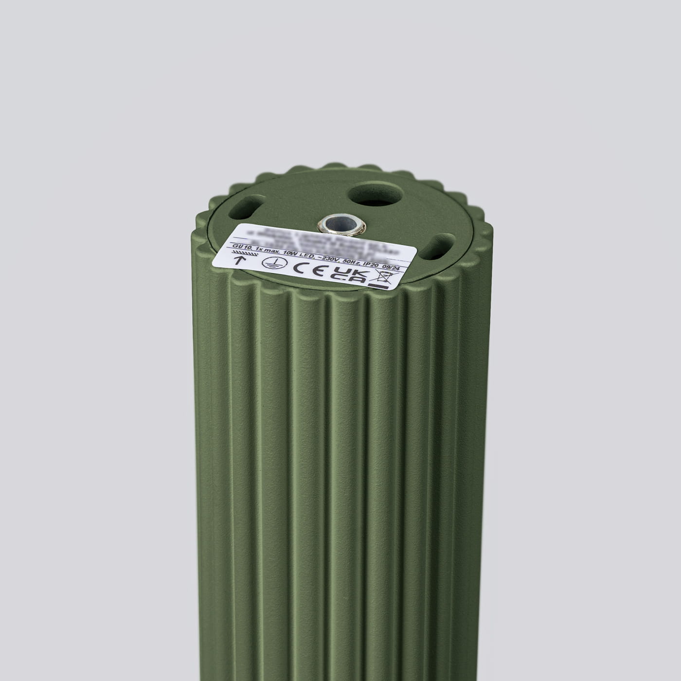 Lampa sufitowa Karbon 30 l z oprawą w kolorze oliwkowym, wykonana z materiału z fakturą pionowych rowków. Widoczny gwint na żarówkę GU10 oraz etykieta z informacjami technicznymi. Ujęcie z góry, ukazujące kształt i detale górnej części lampy.