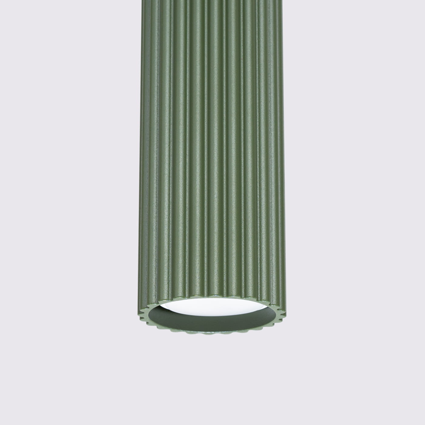 Lampa wisząca Karbon w oliwkowym kolorze, z cylindrycznym, żłobionym kloszem. Ujęcie zbliżeniowe na górną część lampy, ukazujące miejsce na żarówkę GU10 oraz detale faktury. Tło proste, jasne.