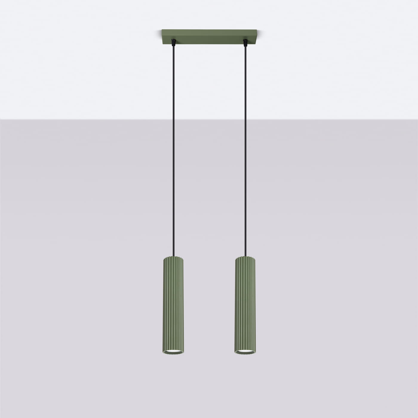 Lampa wisząca Karbon 2 w kolorze oliwkowym, z dwiema cylindrycznymi, rowkowanymi oprawami na żarówki GU10. Zawieszona na czarnych kablach, z prostokątnym, oliwkowym mocowaniem sufitowym.