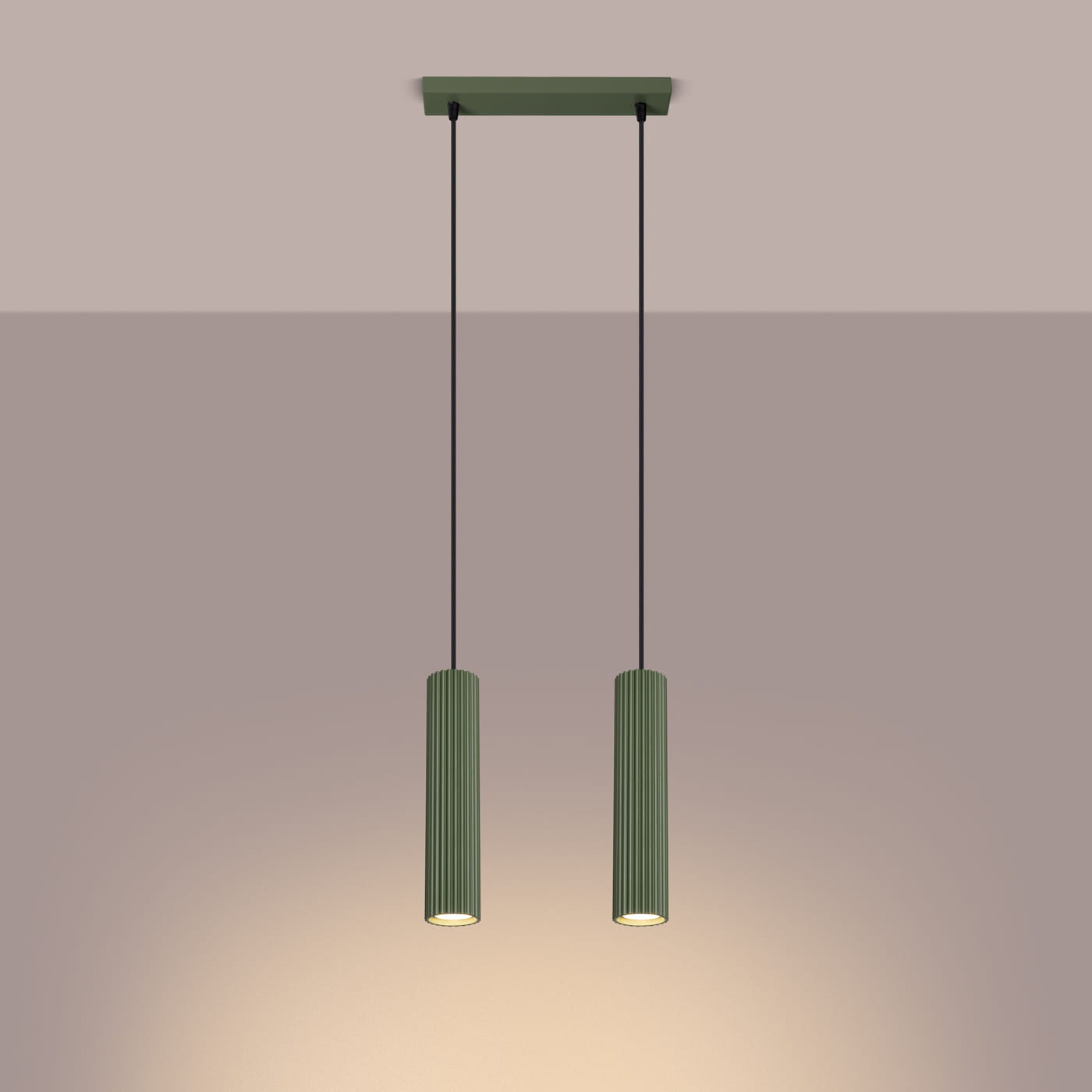 Lampa wisząca Karbon 2, z dwiema żarówkami GU10, w kolorze oliwkowym. Posiada cylindryczne, żłobkowane klosze zawieszone na czarnych przewodach. Montaż sufitowy, w minimalistycznym stylu, na jasnym tle.