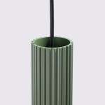 Lampa wisząca Karbon 2 w kolorze oliwkowym, z cylindrycznym kloszem o żłobionej fakturze. Ujęcie z bliska, skupione na górnej części lampy z przewodem w czarnym oplocie. Wnętrze klosza ma gładką powierzchnię.