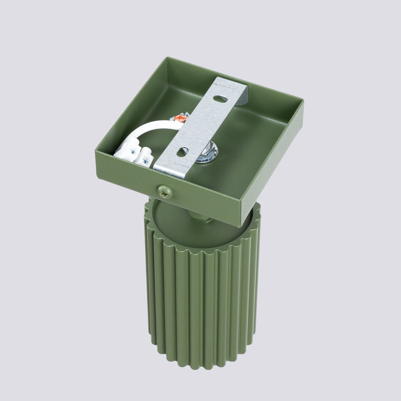 Karbon kinkiet 1xGU10 w kolorze oliwkowym, z okrągłym, żebrowanym korpusem. Ujęcie z góry, pokazujące górną część lampy z mocowaniem. Metalowa płyta montażowa z widocznymi przewodami elektrycznymi. Prosty, nowoczesny design.