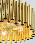 Wisząca lampa Narni 6235/4 w kolorze złotym, z czterema miejscami na żarówki E27. Kształt złożony z pionowych, cylindrycznych elementów w metalicznym wykończeniu, z widocznymi żarówkami, umieszczona na okrągłej podstawie.