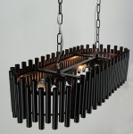 Lampa wisząca Narni w kolorze czarnym, o konstrukcji z cylindrycznych rur, przeznaczona na 8 żarówek E27. Produkt zawieszony na łańcuchu, z widocznymi źródłami światła wewnątrz. Ujęcie z góry, na jednolitym tle.