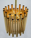 Lampa wisząca Narni 1xE27 w kolorze złotym, składająca się z długich, cylindrycznych rur, ułożonych w okrąg. Produkt widoczny z góry, zawieszony na metalowym stelażu. Idealna do nowoczesnych wnętrz.
