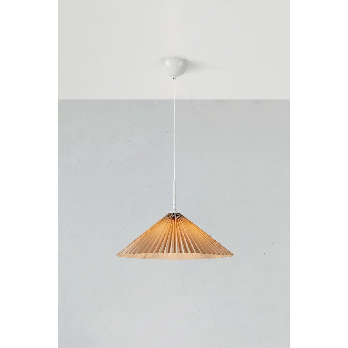 Lampa wisząca Plisado 1xE27 w kolorze białym i beżowym. Kształt stożkowaty z plisowanym abażurem, zawieszona na cienkim przewodzie. Tło w jasnoszarym kolorze, minimalistyczne otoczenie. Idealna do nowoczesnych wnętrz.