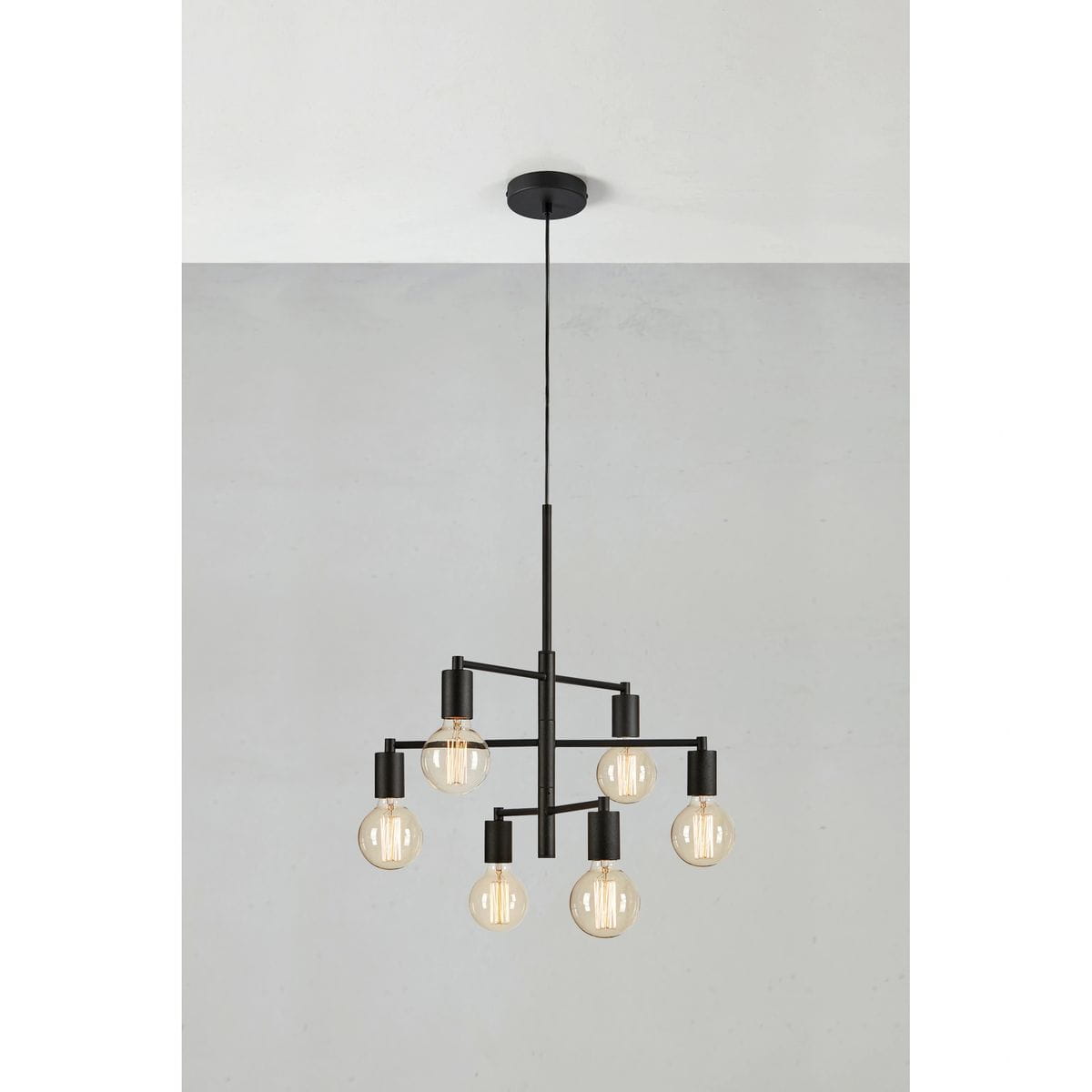 Lampa wisząca Cielo z sześcioma mocowaniami E27 w kolorze piaskowym i czarnym. Produkt ma nowoczesny, minimalistyczny kształt, z równomiernie rozmieszczonymi żarówkami, zawieszony na cienkim kablu. Tło w odcieniach szarości.