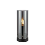 Lampa stołowa z jednym gniazdem E14, o cylindrycznym kształcie. Wykonana z dymnego szkła i czarnego metalu, z widoczną żarówką wewnątrz. Ujęcie frontalne, lampa stoi na płaskiej powierzchni.