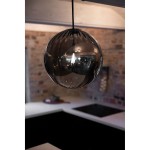 Czarna lampa wisząca Fengari z dymionym kloszem, w kształcie kulistym, zawieszona na cienkim przewodzie. Widoczny połysk szkła oraz subtelne refleksy. Tło to nowoczesna kuchnia z jasnym blatem i ciemną zabudową.