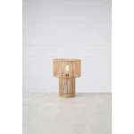 Lampa stołowa Soga z naturalnego materiału, okrągła podsufitka i cylindryczna podstawa. W zestawie żarówka E27. Ujęcie frontalne na szarym tle, lampa świeci, odsłaniając delikatny wzór. Widoczny przewód z włącznikiem.