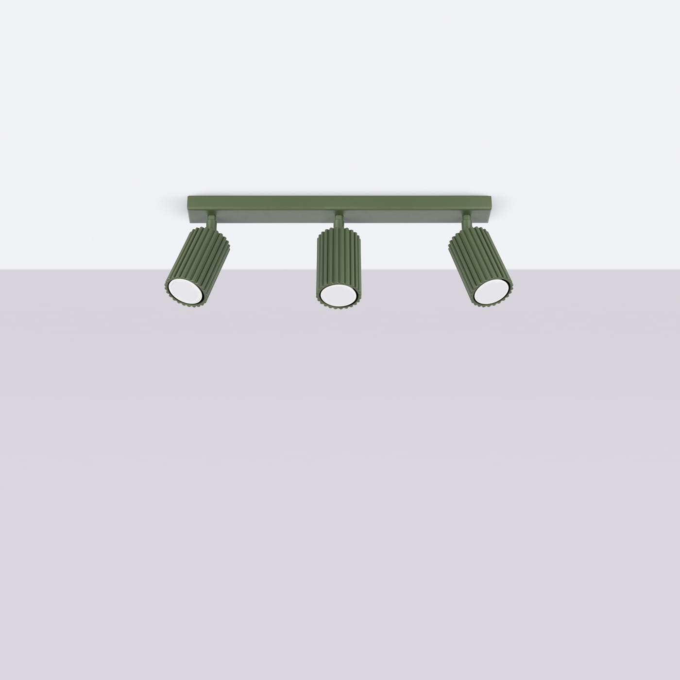 Lampa sufitowa Karbon w kolorze oliwkowym, z trzema reflektorami GU10. Ujęcie frontalne, zamontowana na prostokątnej podstawie. Reflektory mają teksturowany, cylindryczny kształt, skierowane w dół. Tło jasnoszare, proste.
