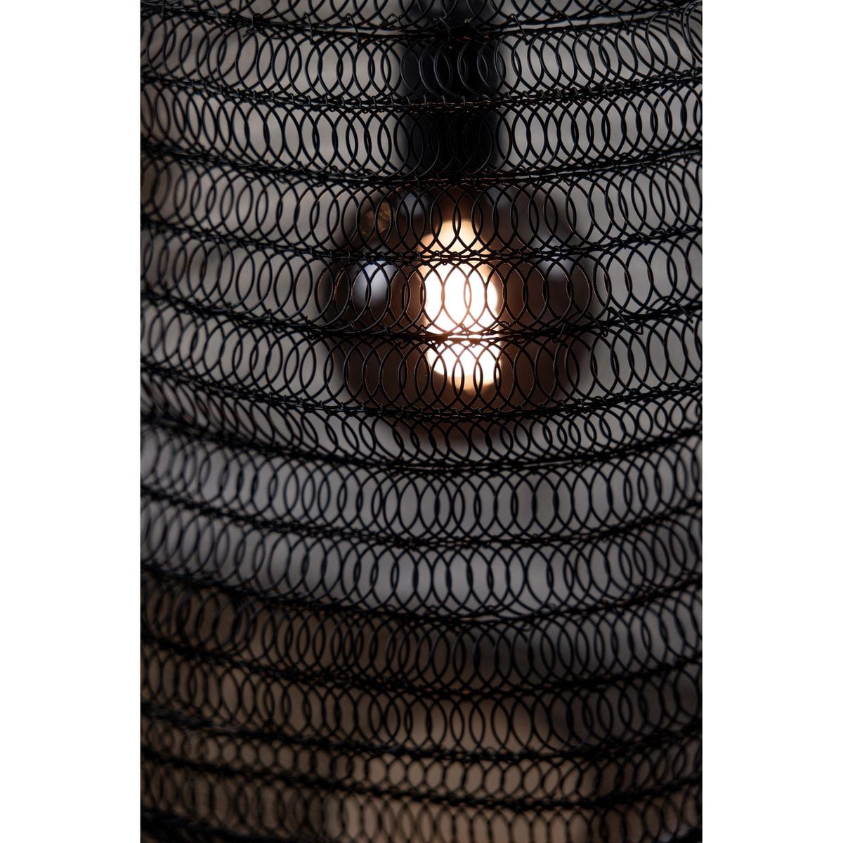 Czarna lampa wisząca Tazza z oprawą na żarówkę E27, widoczna w zbliżeniu. Lampa ma ażurową konstrukcję z metalowej siatki, przez którą prześwituje światło, tworząc niepowtarzalny efekt oświetleniowy.