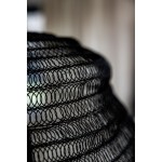 Lampa wisząca Tazza w kolorze czarnym, wykonana z metalowej siatki w formie okrągłego klosza. Ujęcie z boku, zbliżenie na strukturę materiału. Widoczne przestrzenne wzory, które tworzą efektowną iluminację.