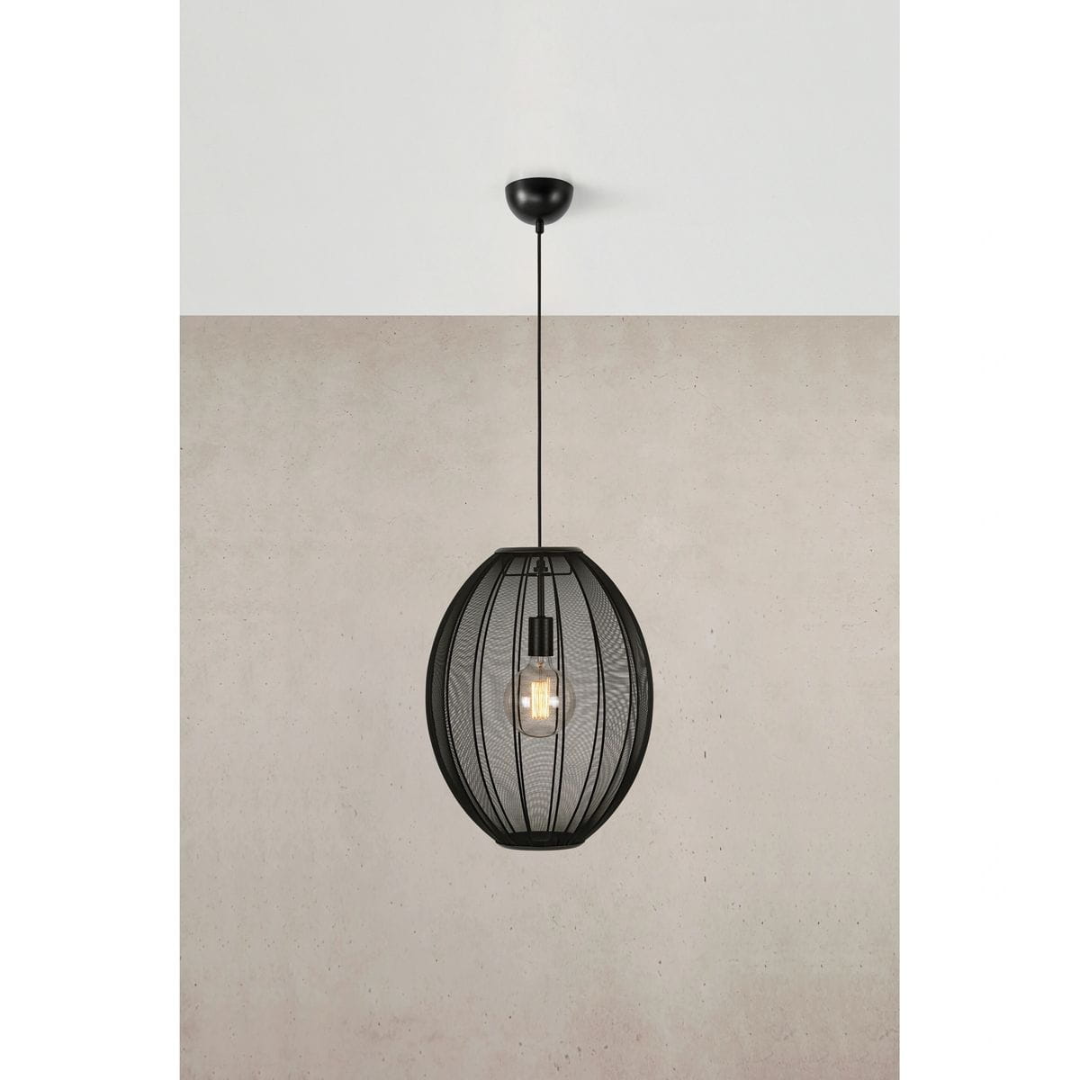 Lampa wisząca Florence D40 w kolorze czarnym, wykonana z metalowej siatki w kształcie owalnym. Zawieszona na cienkim przewodzie, z widoczną żarówką E27 wewnątrz. Tło w jasnym odcieniu betonu, lampa w centralnej części obrazu.