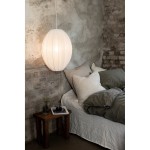 Lampa wisząca Florence D40 w kolorze białym, o owalnym kształcie z delikatnymi liniami. Zawieszona nad łóżkiem w sypialni z szarymi ścianami, obok drewnianego stolika nocnego z książką i szklanką.