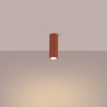 Lampa sufitowa Karbon 20 o cylindrycznym kształcie w kolorze ochry czerwonej, zawieszona pod sufitem. Posiada żarówkę GU10, z widoczną fakturą rowków na powierzchni. Światło skierowane w dół, na prostym tle.
