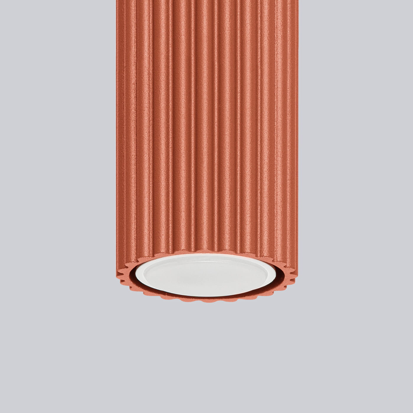 Lampa sufitowa Karbon 30 w kolorze ochra czerwona, z cylindrycznym kloszem o żłobionej fakturze. Ujęcie z dołu, pokazujące okrągły gwint na żarówkę GU10 oraz białą osłonę. Tło jasnoszare, minimalistyczne.