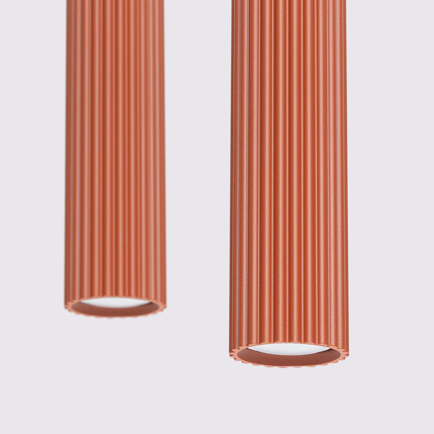 Lampa wisząca Karbon 2 z dwoma kloszami w kolorze ochra czerwona, o fakturze z wyraźnymi żłobieniami. Klosze są umieszczone w pionie, z widocznymi oprawkami GU10 na górze. Tło jest jasne, co podkreśla kolor lampy.