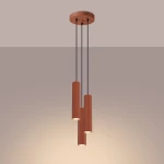Lampa wisząca Karbon 3P z trzema cylindrycznymi kloszami w kolorze ochry czerwanej, zawieszona na czarnych linkach. Klosze mają fakturę z pionowymi żłobieniami, montowana do sufitu na okrągłej podstawie.