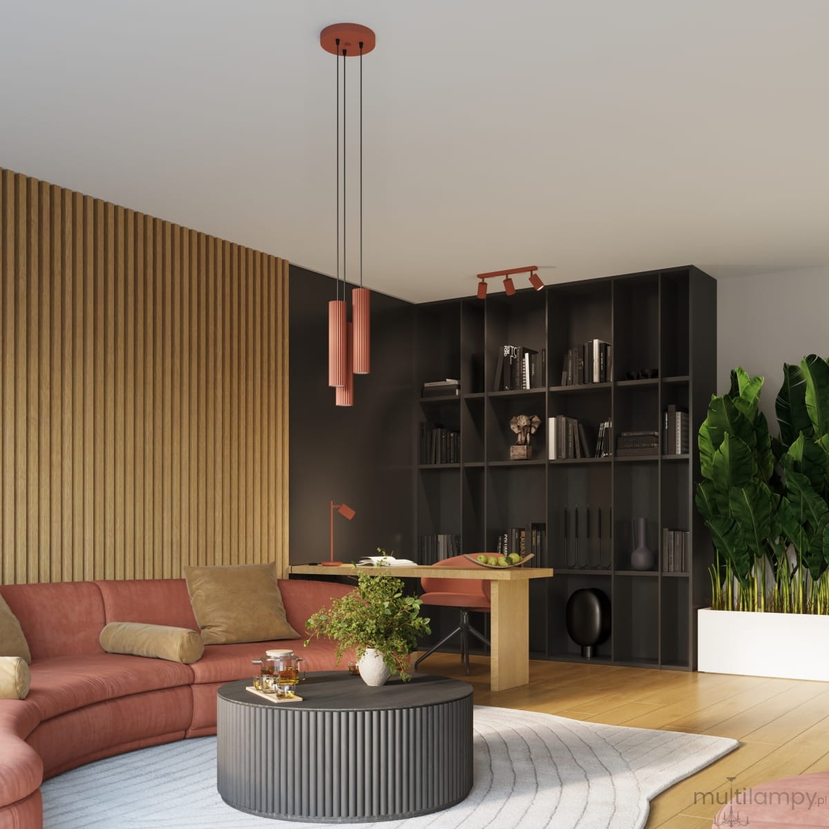 Lampa wisząca Karbon 3P w kolorze ochry czerwonej z trzema oprawami GU10, zawieszona na czarnych linkach. Ujęcie z góry, w nowoczesnym wnętrzu, z regałem w tle oraz roślinnością.