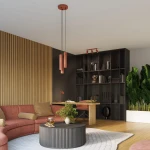 Lampa wisząca Karbon 3P w kolorze ochry czerwonej z trzema oprawami GU10, zawieszona na czarnych linkach. Ujęcie z góry, w nowoczesnym wnętrzu, z regałem w tle oraz roślinnością.